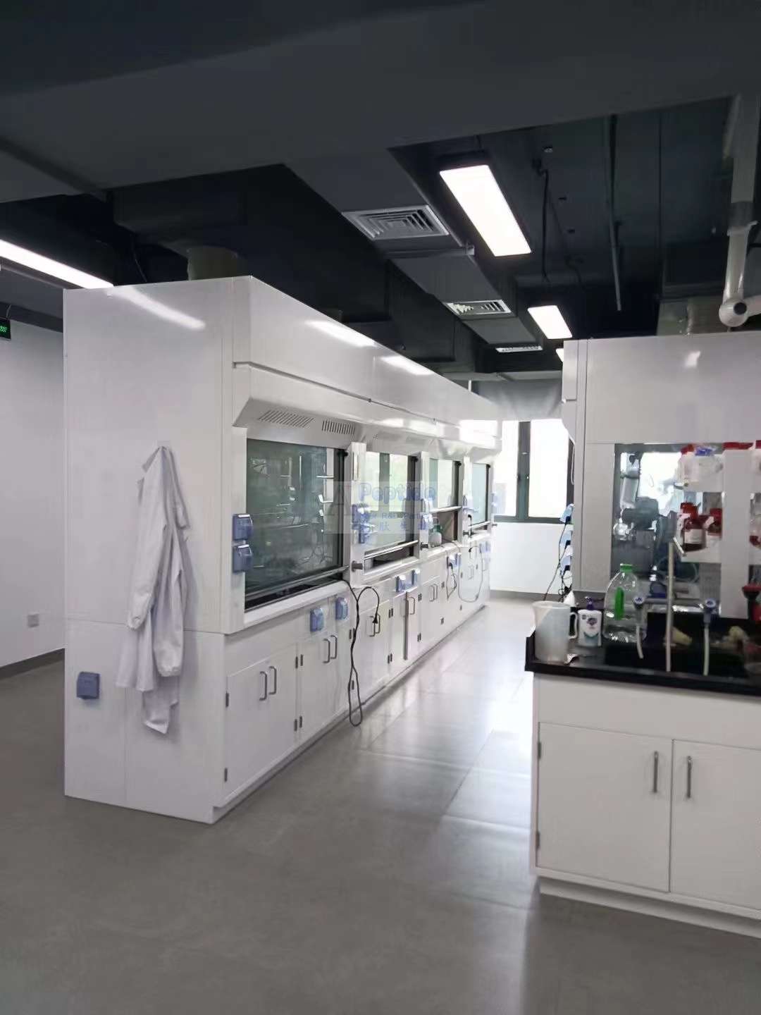 Laboratory team gathered at an instrument in supplied project materials